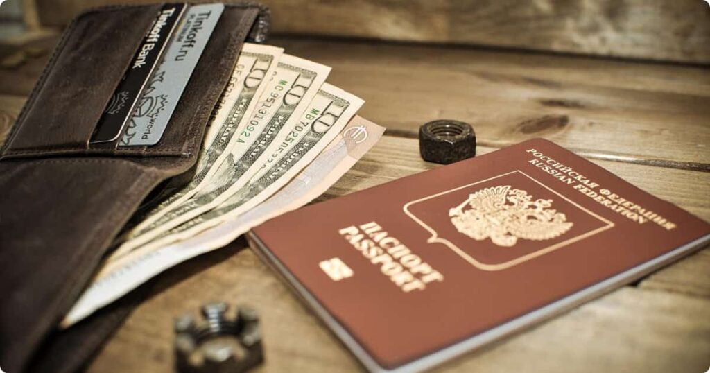 Travel wallet with passport and vaccination card on safari camp table representing hidden African safari costs