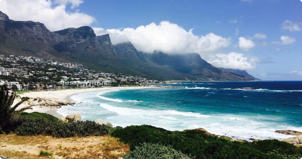 Camps Bay beach in Cape Town with white sand, turquoise Atlantic water, and the Twelve Apostles mountain range behind