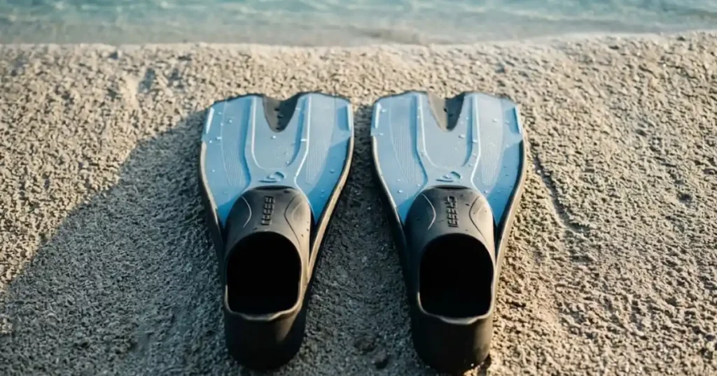 Best snorkeling fins for travel laid on tropical beach sand ready for reef snorkeling