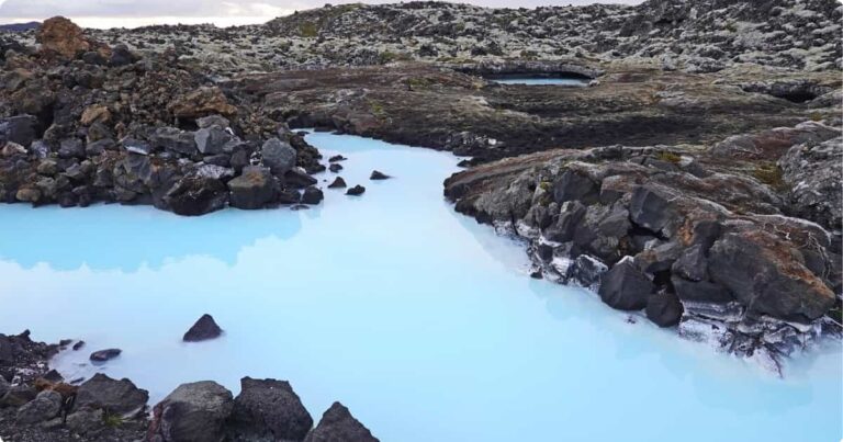 Blue Lagoon Iceland: Complete Guide (Tickets, Tips & What to Expect) Milky-blue geothermal waters of the Blue Lagoon Iceland surrounded by black lava fields and rising steam