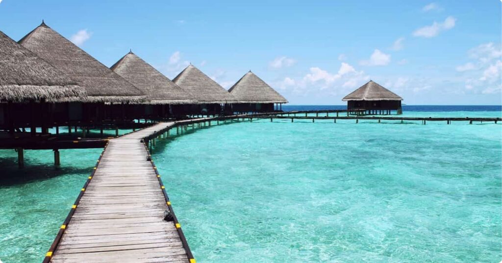 Overwater bungalows over turquoise lagoon at golden hour — Bora Bora vs Maldives vs Moorea comparison guide