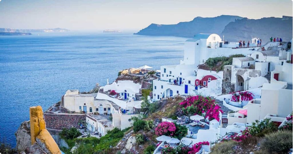 Whitewashed clifftop village of Santorini with blue-domed churches and caldera views at golden hour