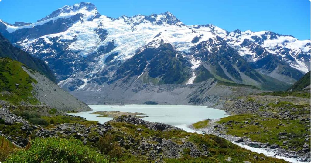Turquoise alpine lake with snow-capped mountains on New Zealand's South Island road trip route