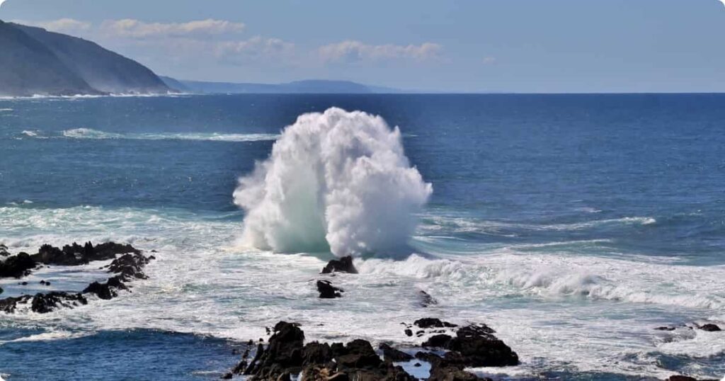 Hiker on Robberg Nature Reserve cliffs overlooking seal colony and Indian Ocean near Plettenberg Bay Garden Route