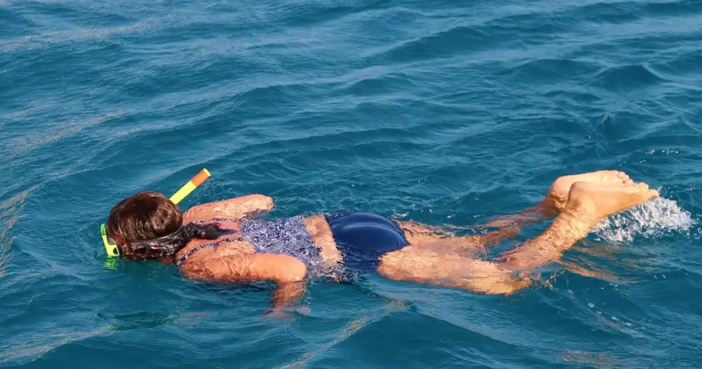 Snorkeler at ocean surface viewed from above in clear turquoise water