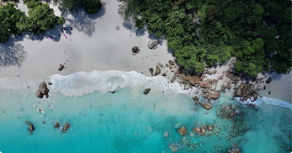 Aerial view of a Seychelles granite island surrounded by turquoise Indian Ocean waters, showing the inner island landscape first-timers should visit