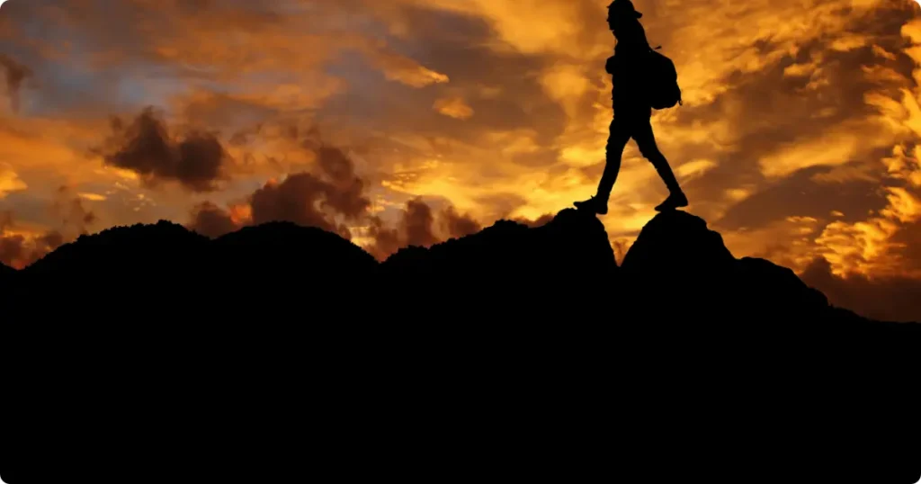 Adventure Travel Guide: Hiking, Snorkeling & Outdoor Destinations 2026 Hiker crossing mountain ridge trail in Montenegro highland at golden hour with valley views below