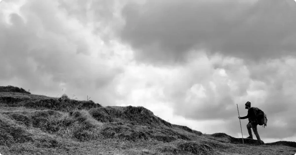 Is Adventure Travel Safe? What the Data Actually Shows Solo hiker on mountain ridge trail with dramatic storm clouds and valley below — adventure travel safety guide