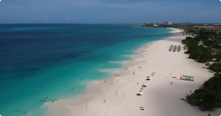 Aerial view of Aruba turquoise coastline and white sand beach at golden hour