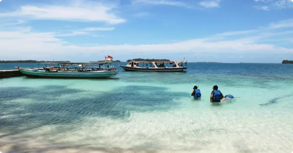 Beginner snorkeler floating in calm shallow turquoise Caribbean water over sandy reef bottom