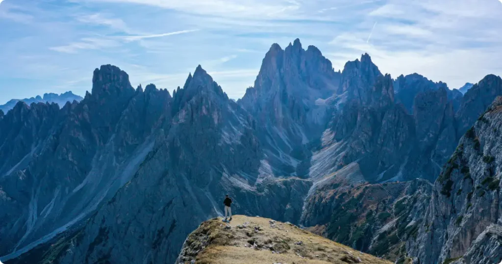 : Solo hiker on alpine ridge trail at golden hour — adventure travel insurance guide for active travelers