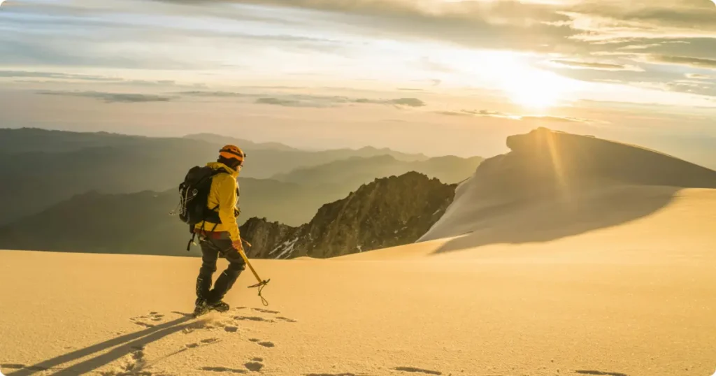 Best Hiking Boots for Travel: Complete Buyer’s Guide 2026 Hiker on rocky mountain ridge trail wearing travel hiking boots at golden hour