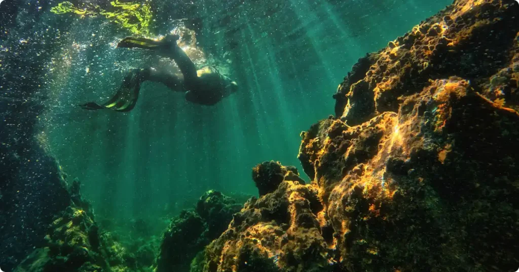 I Tried 5 Snorkeling Destinations: Honest Ranked Review Snorkeler exploring pristine coral reef with sunlight rays in clear tropical ocean water