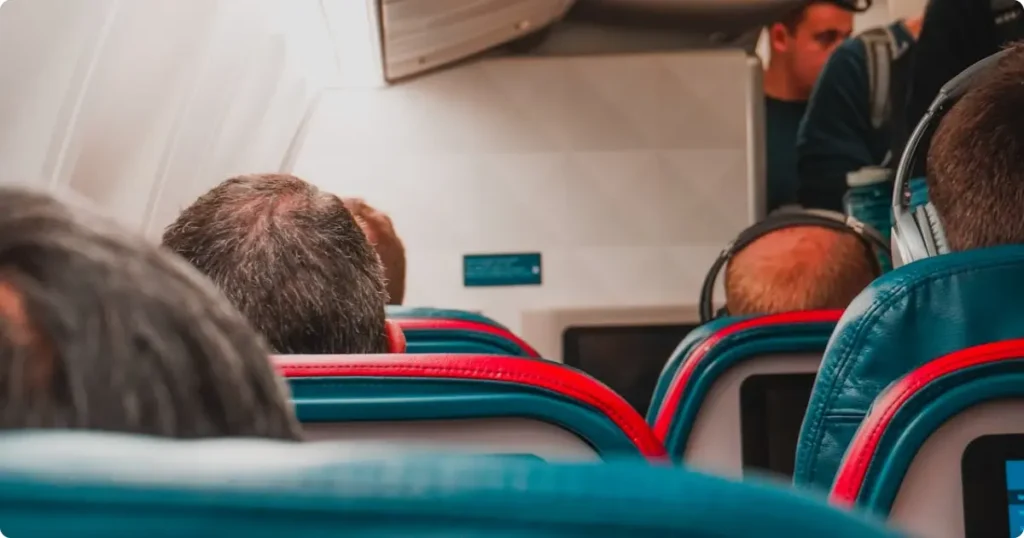 Best travel pillow resting on economy airline seat headrest during long-haul flight