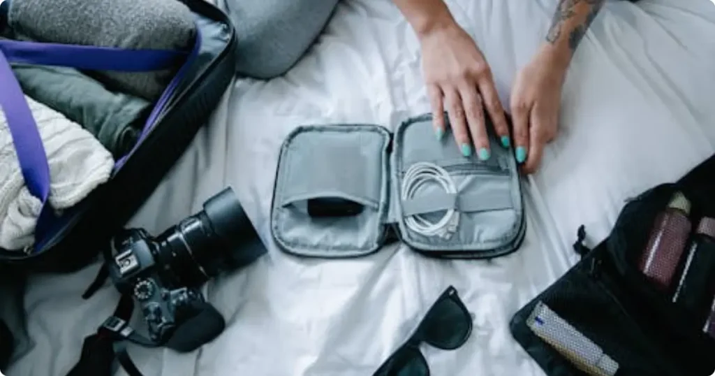 compact carry-on roller bag with rolled clothing and packing cubes on wooden floor for 3-week trip