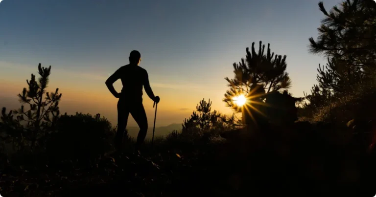 Hiker climbing concrete steps up Hooiberg mountain Aruba at sunrise with Caribbean sky