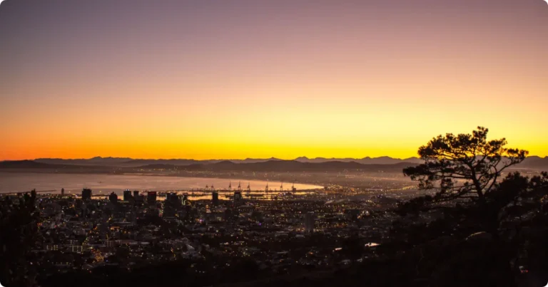 Lion’s Head Hike Cape Town: Complete Trail Guide Hiker at Lion's Head summit overlooking Cape Town and Atlantic Ocean at sunrise