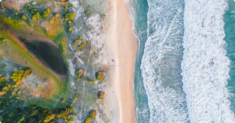 Sint Maarten vs Saint Martin: Which Side is Better for Your Trip? Aerial view of Sint Maarten Saint Martin island coastline with turquoise Caribbean water and white sand