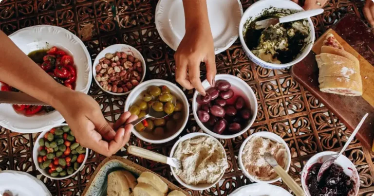 African Food Guide: Most Popular Dishes American Travelers Should Try A spread of popular African dishes including jollof rice, injera, and stews served on a wooden communal table