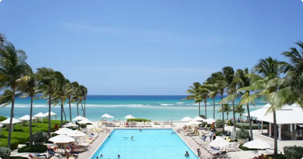 Caribbean resort infinity pool overlooking turquoise ocean, representing the range of accommodation costs across the islands