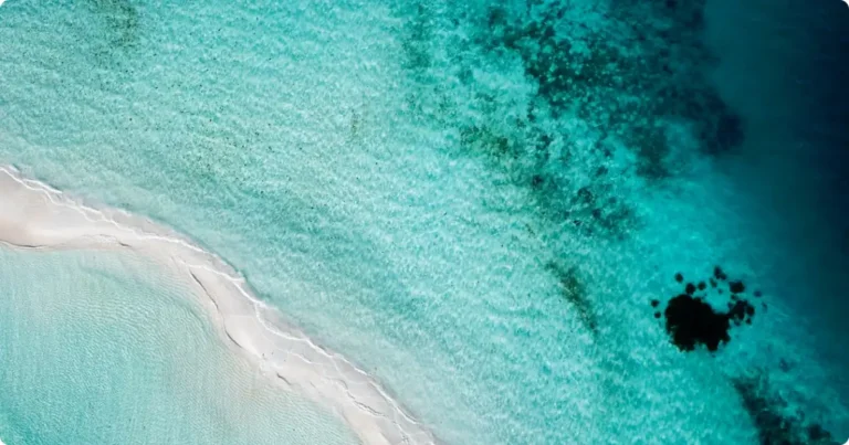 Caribbean, Mexico & Central America Travel Guide: Best Islands & Destinations Aerial view of turquoise Caribbean water showing reef depth — Caribbean Mexico and Central America travel guide