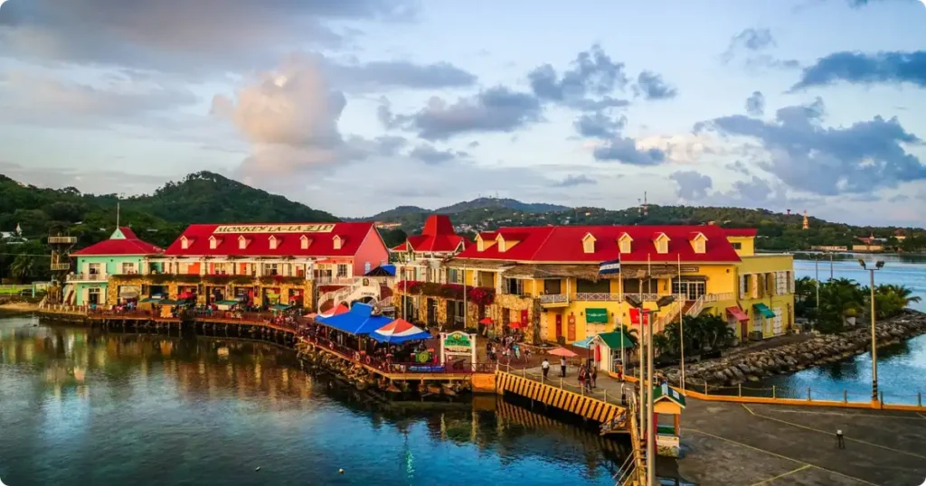 Colourful colonial waterfront buildings in Willemstad Curaçao reflected in blue harbour water, a top budget Caribbean destination for families