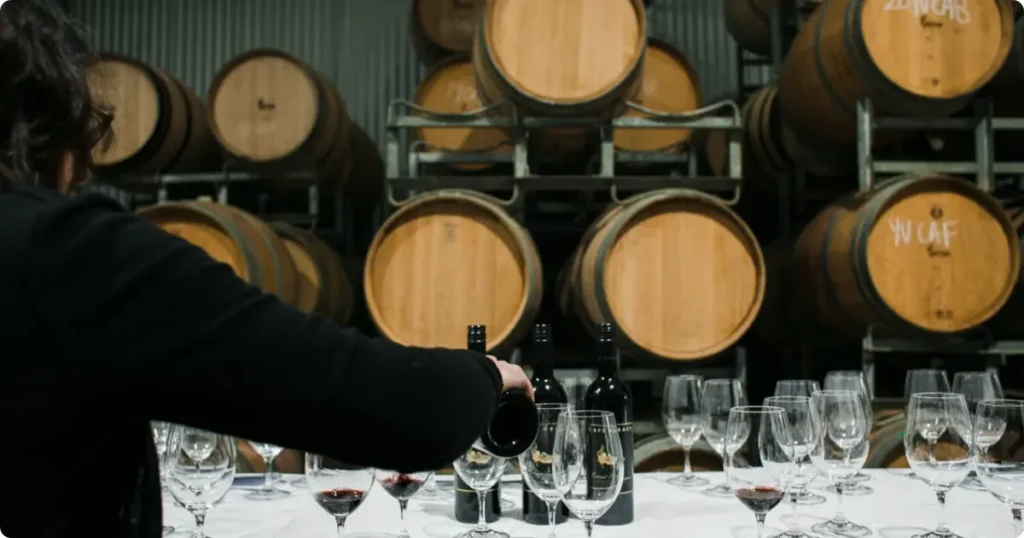 Port wine tasting at a Douro Valley quinta, with glasses and oak barrels in a traditional cellar setting