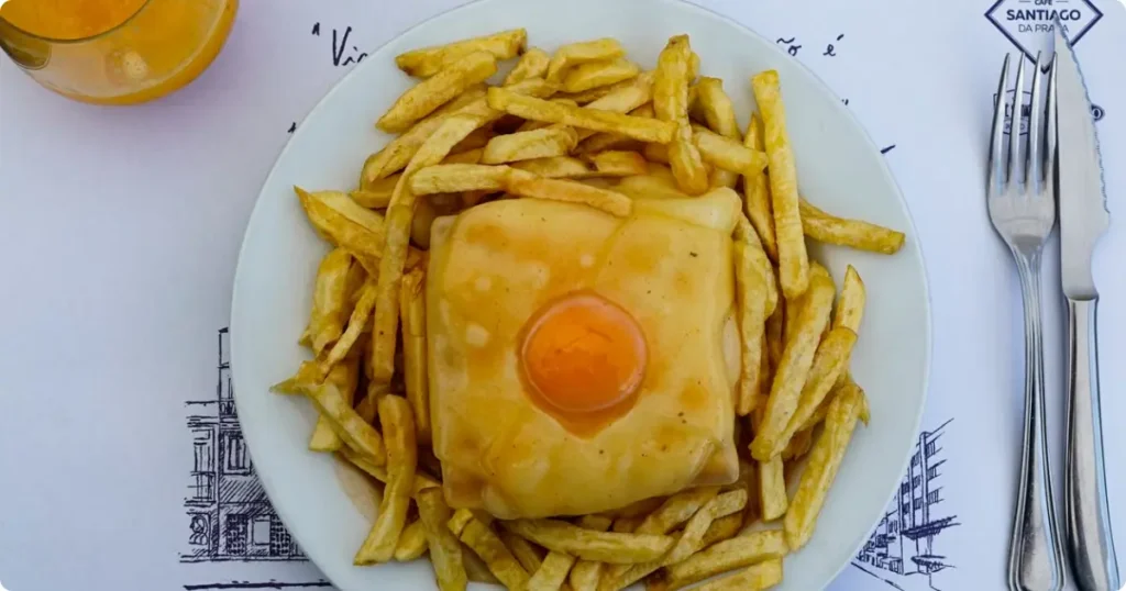 Francesinha Porto's iconic layered meat sandwich with melted cheese and spicy beer sauce, a staple on every Porto food tour