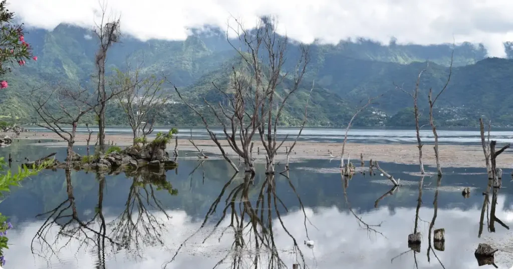 Traditional Maya village on the shore of Lake Atitlán Guatemala with volcanic peaks in the background