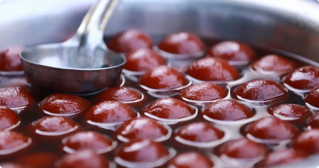 Golden syrup-coated South African koeksisters on a wooden board, a traditional Afrikaans sweet treat